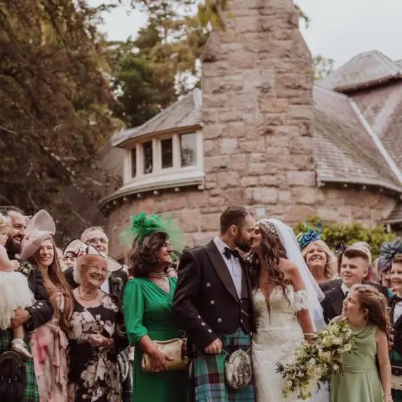 Wedding party outside showing guests with bride and groom.